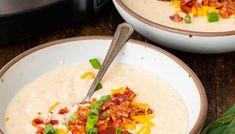 two bowls filled with soup and topped with bacon