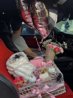 a person in a car with some balloons and other items on the back seat,