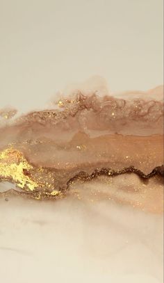 an abstract painting with gold and white paint on top of the water, in shades of brown