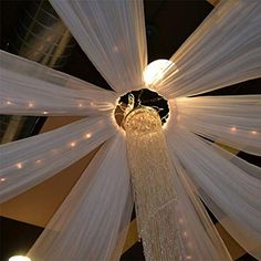 the ceiling is decorated with white drapes and lights