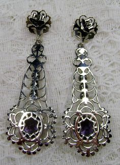 Simulated Purple Amethyst Solid Sterling Silver Earrings Lavaliere Design#E17 Inspired by Victorian era designs, I now offer these lovely Antique estate reproduction earrings in sterling silver (recast from an Antique lavaliere pendant). Each stunning 4 carat flawless Man-made/simulated purple amethyst is 11mm long (just under 1/2") and 9mm in width (3/8"). The lovely amethyst have an excellent light purple color. The earrings are just over 2" inches in length. These earrings are ethereal and cl Purple Earrings With Intricate Design As Gift, Purple Earrings With Intricate Design For Gift, Ornate Purple Pierced Earrings, Purple Pierced Earrings For Wedding, Ornate Purple Sterling Silver Earrings, Ornate Purple Jewelry With Matching Earrings, Elegant Purple Pierced Jewelry, Ornate Purple Dangle Jewelry, Ornate Purple Dangle Earrings