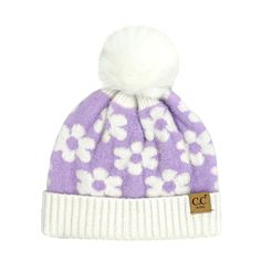 a purple and white beanie with flowers on the front, one pom - pom