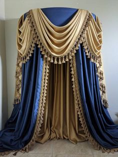 a canopy bed with blue and gold drapes