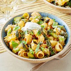 two bowls filled with pasta and vegetables on top of a table