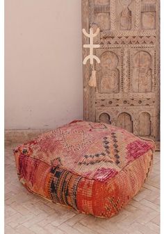 a large ottoman sitting on top of a wooden floor next to a tall white cross