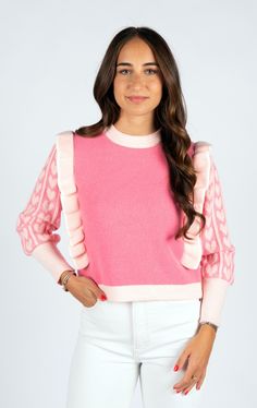 Get ready to charm the cold with our Sweetheart Sweater! This playful pink sweater is sure to make hearts flutter with its sweet ruffles. Stay cozy while looking oh-so-cute in our lovable knitwear. Perfect for any sweetheart looking for a stylish and sweet winter wardrobe addition! Cute Pink Heart Print Sweater, Playful Pink Loungewear Sweater, Playful Pink Ruffled Tops, Playful Pink Winter Sweater, Cute Long Sleeve Sweater With Ruffles, Cozy Textured Knit Pink Tops, Pink Knit Sweater With Heart Print, Pink Ruffled Winter Top, Pink Ruffled Tops For Winter