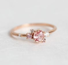 Rose gold peach saphire ring. Unique sideways cluster design by Minimalvs. Beautiful and unique sapphire cluster ring. The design can be made with gemstones of your choosing. If you would prefer a custom ring, please contact us before purchase. ★Details Main gemstone: pink, peach sapphire, VS clarity Shape: oval Measurements: approx. 4.5 - 5 x 3.5 mm Side stones: -pink sapphire: 2.25 mm -purple sapphire: 1.55 mm -white diamonds: 2 mm, 1.35 mm, 1.25 mm Quality: G color, VS clarity, conflict-free Peach Sapphire Engagement Ring Rose Gold, Peach Sapphire Rings, Peach Sapphire Engagement Ring, Diamond Sapphire Engagement Ring, Sapphire Diamond Engagement, Gold Sapphire Ring, Peach Sapphire, Diamond Cluster Engagement Ring, Engagement Ring Rose Gold