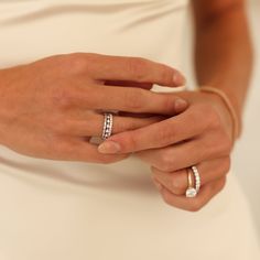 a woman's hands with two rings on her finger and one ring in the other hand