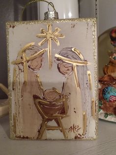 a glass ornament with an image of two people and a baby in a manger