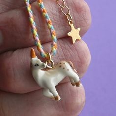 Introducing our enchanting Unicorn charm bracelet, the perfect accessory to add a touch of magic to your day. This delightful porcelain charm pays homage to the mythical unicorn, a symbol of purity, grace, and imagination. With intricate hand-painted details, this Unicorn charm is a timeless and heirloom-quality addition to any collection. The charm hangs on a cotton braided cord bracelet with a golden steel extension, making it comfortable to wear and easy to adjust. Whether you're a lover of a White Charm Bracelet With Star Charm As Gift, White Unicorn Print Jewelry For Gifts, White Unicorn Print Jewelry For Gift, Mythical Unicorn, Steel Extension, Giraffe Necklace, The Artist Movie, Horses Theme, Unicorn Charm