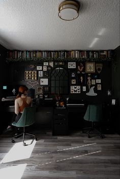 a woman sitting at a computer desk in front of a book shelf filled with books