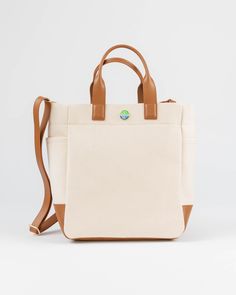 The Cape Code Tote is a truly elevated and refined take on the classic design. The design featured dual handles and a detachable strap for convenience. The spacious interior will fit all your daily needs and even works as a weekender or picnic bag. The streamlined style complements any outfit and works for his, hers, and theirs. • Natural/Saddle • 100% cotton with leather trim • Unlined • Two exterior side pockets • Leather bottom • Detachable & adjustable strap • 6” handle drop • Measures 11.5” Versatile Satchel With Leather Handles For On-the-go, Modern Travel Bag With Handles For On-the-go, Beige Travel Bag With Leather Handles For Everyday Use, Functional Everyday Satchel With Detachable Handle, Versatile Travel Tote Bag With Detachable Handle, Modern Travel Bag With Detachable Top Handle, Versatile Tote Travel Bag With Detachable Handle, On-the-go Canvas Bag With Detachable Strap, Beige Canvas Travel Bag With Double Handle