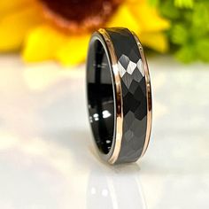 a black and gold wedding ring with an argyle pattern inlayed to the center