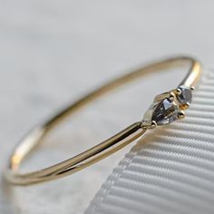 a close up of a gold ring with a diamond on the top and an invisible band around it