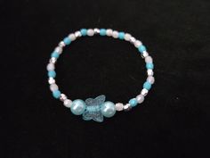 A handmade blue butterfly and white beaded bracelet with a blue butterfly charm.  One size fits all. Made with Elastic crystal beading core. White Beaded Bracelet, Bracelet Blue, Bracelets Handmade Beaded, Butterfly Charm, Blue Bracelet, Blue Butterfly, Beaded Bracelet, One Size Fits All, Halloween Shopping