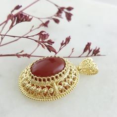 This beautiful pendant showcases a genuine 13x18mm carnelian gemstone set in an intricate gold filigree design with a diamond-cut mirror finish. Handcrafted with attention to detail, it adds elegance and sophistication to any necklace. Perfect for making a statement or as a unique gift. ✓Length : 1 3/4 inch Width : 1 1/16 inch Carnelian Pendant, Bronze Jewelry, Filigree Pendant, Filigree Design, Gold Filigree, Diamond Cut, Diamond Cuts, 4 Inch, 18k Gold