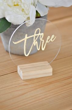 a clear acrylic sign with the word free on it sitting next to flowers