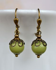 VINTAGE ELEMENTS Unique Jewellery, Handmade from Vintage Inspired, Original Designs Art Nouveau style antiqued brass earrings with pale Olive Green Glass drops and ornate filigree bead caps. These earrings are made with antiqued brass leverback earwires and measure 3.2cm from the top of the earwires. Art Nouveau Antiques, Glass Drop Earrings, Vintage Elements, Jewellery Handmade, Brass Earrings, Bead Caps, Green Glass, Antique Brass, Original Design