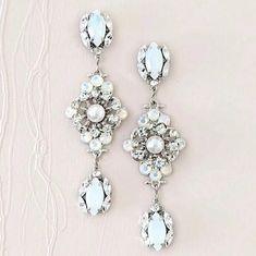 These long bridal earrings are a superb choice for brides who want to add some subtle color with white opal and glam to their wedding... Glamorous White Chandelier Earrings With Sparkling Stones, Formal White Crystal Chandelier Earrings, White Crystal Chandelier Earrings For Formal Occasions, Formal White Chandelier Earrings With Sparkling Stones, White Chandelier Earrings With Sparkling Stones For Anniversary, Anniversary White Chandelier Earrings With Sparkling Stones, Glamorous White Bridal Earrings With Elegant Design, Elegant White Chandelier Earrings With Sparkling Stones, White Elegant Chandelier Earrings For Formal Occasions