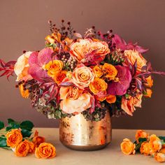 a vase filled with lots of different colored flowers