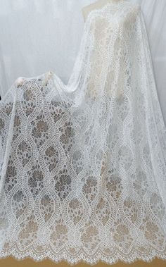 a white crochet lace shawl on a mannequin