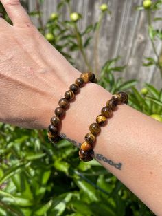 Tiger's Eye Beaded Bracelet 8mm round beads Tiger's Eye, a crystal with glowing bands of yellow golden hues that brings strength and will power! A stone of protection, Tiger's Eye is believed to be watching over its' people and 'keep an eye open' for them!  Approx. 7inches around/ The bracelets are stretchy and fits most peoples' wrists.  Also sometimes referred as Tiger's Eye, Tiger Eye, Cat's Eye. This listing for one (1) Tiger's Eye stretchy bracelet. Thank you for checking out this listing! This treasure helps support my small business and my mission to recycle and reduce waste in our city! Orders over $35 get FREE shipping! To stay updated with new items follow us on Instagram @Tumbledshop  OR Click the link below!  https://www.instagram.com/tumbledshop/ Tigers Eye Bracelet Men, Adjustable Spiritual Crystal Bracelet With Polished Beads, Spiritual Hand-strung Evil Eye Bracelet For Healing, Spiritual Beaded Evil Eye Bracelet For Healing, Brown Gemstone Beads Crystal Bracelet For Healing, Spiritual Healing Evil Eye Bracelet With Round Beads, Brown Crystal Bracelet With Gemstone Beads For Healing, Spiritual 8mm Beads Wristband For Healing, Healing Beaded Evil Eye Bracelet With Round Beads