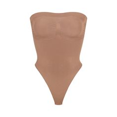 Cinch your waist and sculpt your tummy and core in this perfectly compressive strapless thong bodysuit. Wear it your way with removable adjustable straps that convert to shoulder straps, cross-back, or halter-style. Features center front and side stitching to define and support your bust, and a cotton gusset with snap closure. Fits true to size. | SKIMS Strapless Thong Bodysuit | Medium Neutral | Seamless Sculpt High Cut Nylon Bodysuit With Built-in Bra, Strapless Nylon Tube Top With Built-in Bra, Sculpting Backless Swimwear With Built-in Bra, Seamless Stretch Tube Top, Strapless Shaping Bodysuit With Built-in Bra, Strapless Shapewear With Built-in Bra, Stretch Tube Top With Built-in Bra And Underwire, Smoothing Bandeau Solid Tube Top, Solid Smoothing Bandeau Tube Top