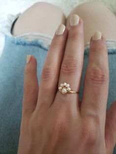 This dainty little pearl cluster ring is a nod to a bohemian vintage style. I've hand hammered the band for strength, texture and shine, then wrapped sweet freshwater pearls in a half halo/flower style. Delicate but strong, this ring is very lightweight and comfortable! ~Choose from~ 14k gold fill 14k rose gold fill Sterling silver What is 14k Gold-fill? Gold fill does not tarnish or wear off and contains 100 times more gold than plated jewelry. It legally must contain at least 5% gold by weight 14k Gold Filled Midi Rings For Wedding, Delicate Tiny Midi Rings For Wedding, Dainty Cluster Promise Ring, Dainty Handmade Midi Rings For Anniversary, Small Dainty Midi Wedding Rings, Dainty Flower Promise Ring, Delicate Pearl Charm Ring For Wedding, Delicate Pearl Drop Wedding Rings, Delicate Gold Pearl Open Ring