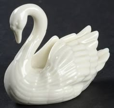 a white swan figurine sitting on top of a table