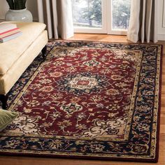 a living room area with a couch, chair and rug in front of a window