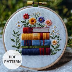 a cross stitch book with flowers and leaves on it