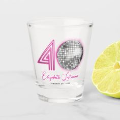 a shot glass with the number forty on it next to a lemon