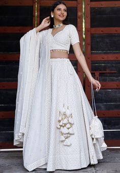 Faux Georgette Lehenga in White. This attire with Cotton Lining is Enhanced with Chicken Embroidery with Resham, Sequins work along with Fancy Tassels, Matching Potli and Can Can Net. Available with a Readymade Faux Georgette White Choli and a Faux Georgette Dupatta in White. The Readymade skirt will be provided. Lehenga Length is 40 inched.Do Note: Accessories shown in the image are for presentation purposes only and length may vary upto 2 inches.(Slight variation in actual color vs. image is p White Georgette Lehenga, Trendy Lehenga Designs, Lehenga Simple, Lehenga White, Chicken Embroidery, Fancy Tassels, Bridesmaid Dresses Indian, Indian Bridesmaid Dresses, Simple Lehenga