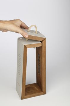 a hand reaching into a box that is sitting on top of a wooden stand with the lid open