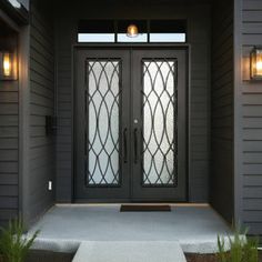 the front door to a house with two glass doors and sidelights on either side