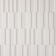 a white tile wall with vertical lines on it's sides and diagonals in the middle