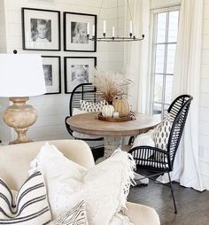 a living room filled with furniture and pictures hanging on the wall above it's windows