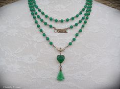 "A gorgeous Jade glass multi strand Art Deco necklace in classic Egyptian Revival style with vintage jade glass beads and cabochons. It makes the perfect handmade women's gift for anyone who loves vintage style Egyptian jewelry. Made from strands of 6mm vintage Cherry brand jade glass beads, a brass Sphinx connector charm, and a 14mm Jade glass heart-shaped scarab with a textured, mixed light and dark Jade glass fan pendant. The smallest row in this necklace measures 15\" closest to the throat, Vintage Multi-strand Gemstone Beads Necklace, Vintage Multi-strand Gemstone Bead Necklaces, Vintage Multi-strand Gemstone Beads Jewelry, Adjustable Vintage Jade Necklace, Vintage Adjustable Jade Necklace, Adjustable Vintage Jade Necklaces, Vintage Adjustable Jade Necklaces, Vintage Jade Beaded Necklace, Vintage Jade Beaded Necklaces