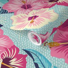 a pink and blue flowered wallpaper with large flowers on the side, next to a pair of scissors