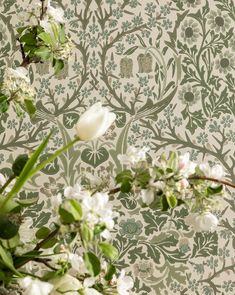 white flowers and green leaves on a wallpapered background with an owl in the middle