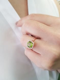 "A round Peridot surrounded by 24 diamonds in a cushion shape halo. A really distinctive luxury ring, the perfect choice for an engagement ring. Item Details ❤ Made to Order ✔ Available Gold Color: Rose Gold, Yellow Gold, White Gold ✔ Number of Blue Topaz: 1, Diameter approx 8mm, total CTW approx:1.85 Ctw ✔ Number of Diamonds: 24, total CTW: 0.17 Ctw ✔ Diamond Color-Clarity: G Color, VS Clarity ✔ Width approx: 10mm x10mm ✔ Height on top: 5.2mm ✔ The band details: Width: 1.70mm Thickness: 1.60mm Green Cushion Cut Diamond Ring With Center Stone, Green Cushion Cut Diamond Jewelry, Peridot Rings With Halo Setting For May Birthstone, Green Cushion Cut Ring, Fine Jewelry, Green Cushion Cut Ring With Prong Setting, Fine Jewelry Green Cushion Cut Ring, Lime Green Diamond Ring With Gemstone, Green Cushion Cut Jewelry With Halo Setting, Green Cushion Cut Halo Setting Jewelry