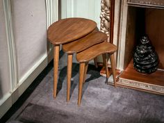 three wooden tables sitting next to each other in front of a fireplace