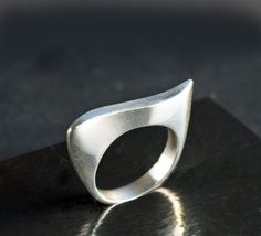 Elegant classic ring featuring a modernist wave design. The ring's fluid curves make an abstract art statement and it has a beautiful handmade look and feel. The ring's inner diameter is about 18.14, making the size a US size 8. The band measures 4 mm wide and is marked 925. The silver band has a few tiny nicks and scratches, consistent with wear and age. When wearing the ring, you don't notice these scratches - what you notice is the beauty of the ring's design and the excellent craftsmanship. Please zoom in each picture to see the tiny dings and scratches that are naturally acquired over time. These can be polished out, however, such marks are part of the ring's history and I'd recommend that you leave the marks and add your own personality and history to the piece :)  The pictures in my Modern Twist Curved Ring With Polished Finish, Modern Twist Curved Rings With Polished Finish, Modern Curved Rings With Polished Finish, Modern Wavy Rings With Polished Finish, Modern Silver Wavy Rings, Modern Wavy Jewelry For Formal Occasions, Modern Curved Jewelry With Polished Finish, Wax Tutorial, Abstract Ring