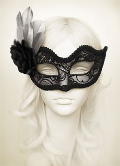 Venetian style masquerade mask covered black lace on metallic silver surface. Framed with black braided trim, small black rhinestones on the corners of the eyes. Decorated with black satin rose and silver feathers. Your order will be delivered with online tracking by UPS or TNT. Back surface is also covered with fabric for comfortable use. Ribbons are added both sides to tie. Base mask is made of paper mache. Standard size fits most (for women). This classical Venetian mask is perfect for any co Luxury Black Elegant Masks, Elegant Black Mask For Costume Party, Gothic Black Eye Masquerade Mask, Black Gothic Eye Mask For Masquerade, Black Eye Mask For Evening Masquerade, Black Venetian Masquerade Mask For Party, Black Venetian Mask For Masquerade, Black Masquerade Mask For Halloween Wedding, Black Venetian Masks And Prosthetics For Masquerade