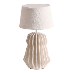 a white ceramic lamp with a shade on it