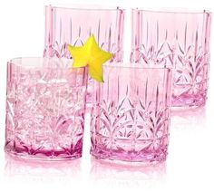 four pink glasses with yellow star decoration on them