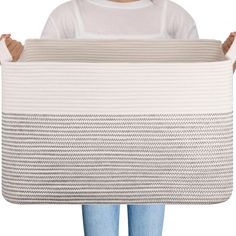 a woman holding up a white and beige basket