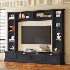 an entertainment center with bookshelves and a flat screen tv mounted on the wall