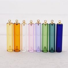 six different colored lighters lined up in a row on a white surface with gold caps