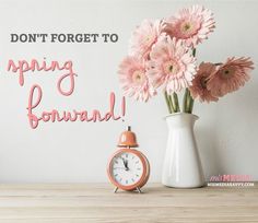 pink flowers and an alarm clock sitting on a table with the words don't forget to spring forward